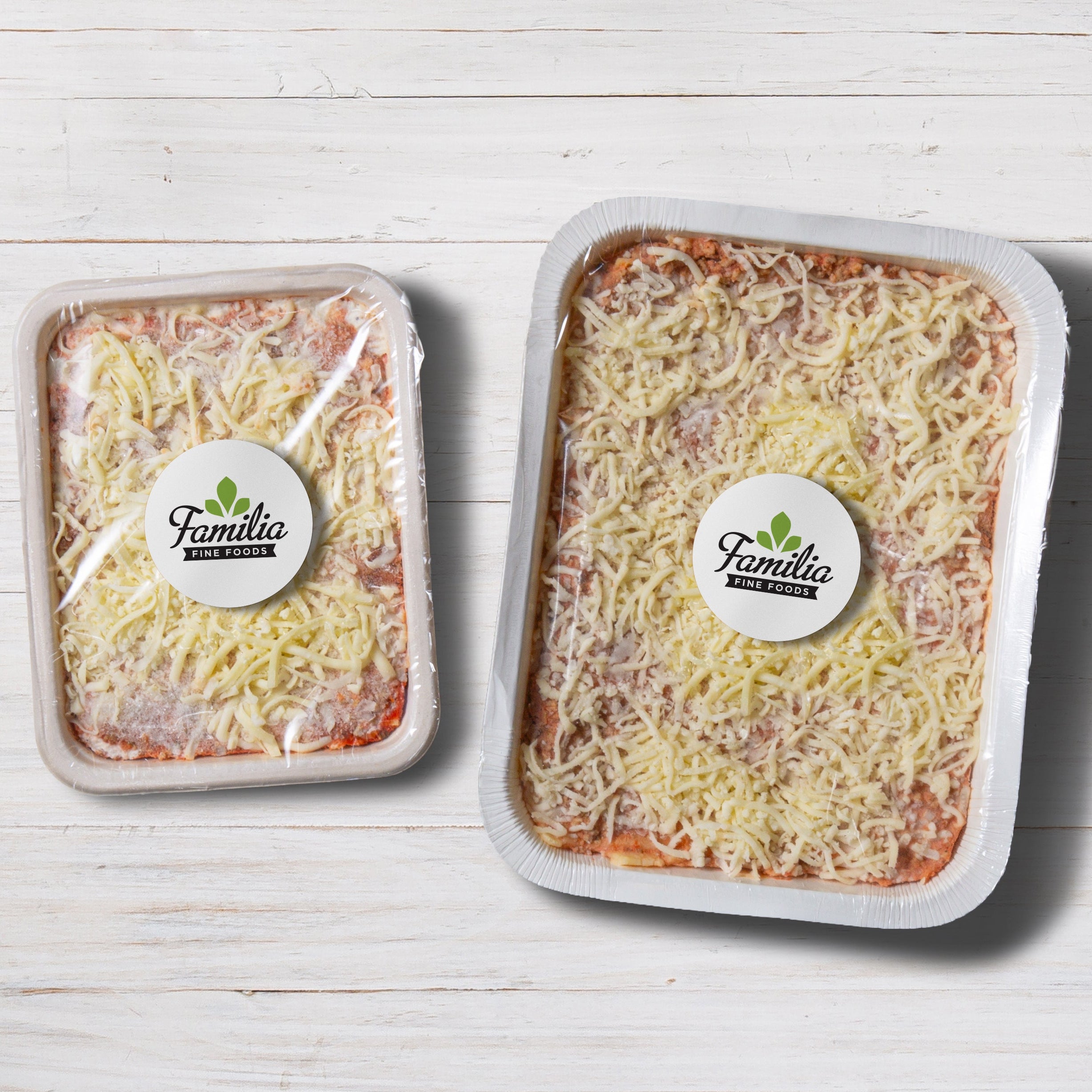 Two packages of Lasagna on a white wooden surface with 'Familia' branding.